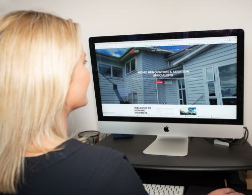 image of a person sitting in fron of a computer with a website displaying