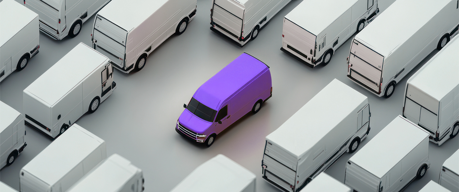 one bright purple van standing out in a crowd of plain white vans